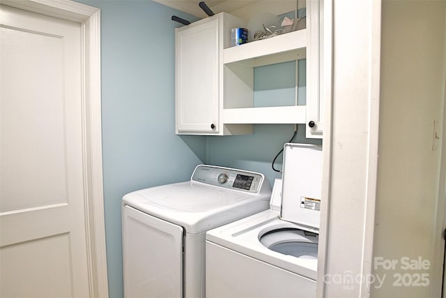 laundry area with independent washer and dryer and cabinet space