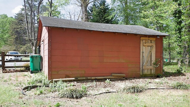 view of outdoor structure with an outbuilding and fence
