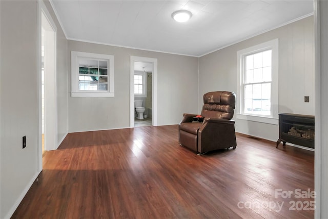 living area featuring visible vents, crown molding, and wood finished floors