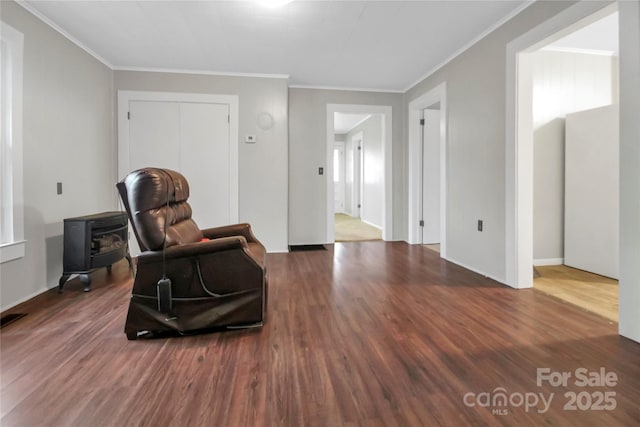 living area featuring visible vents, crown molding, and wood finished floors