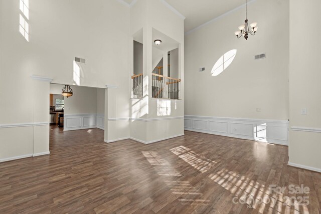 15814 Herring Gull Way, Charlotte, NC 28278 - unfurnished living room with a towering ceiling, visible vents, a notable chandelier, and wood finished floors