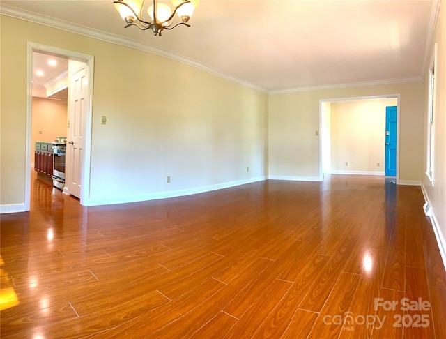 spare room with baseboards, crown molding, dark wood-style floors, and an inviting chandelier