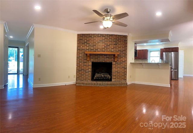 unfurnished living room featuring baseboards, recessed lighting, wood finished floors, ceiling fan, and ornamental molding