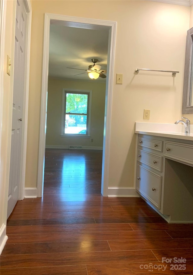 bathroom featuring wood finished floors, visible vents, vanity, baseboards, and ceiling fan
