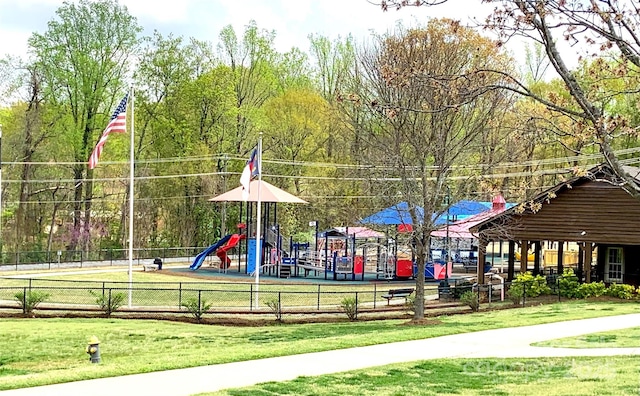 community jungle gym featuring a yard and fence