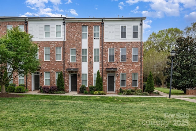 multi unit property featuring a front lawn and brick siding