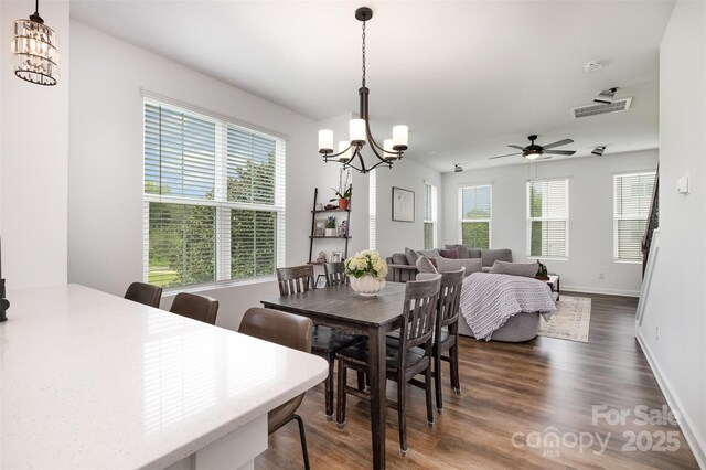 dining area with a chandelier, dark wood-style flooring, and baseboards