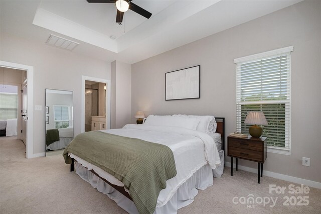 bedroom featuring light carpet, multiple windows, and baseboards