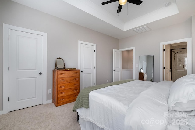 bedroom featuring light colored carpet, a raised ceiling, and ceiling fan