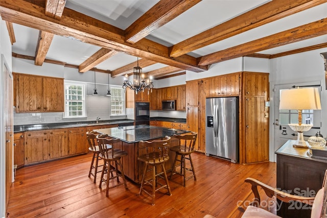 1233 General Hoke Dr, Lincolnton, NC 28092 - kitchen featuring dark countertops, tasteful backsplash, brown cabinetry, and appliances with stainless steel finishes