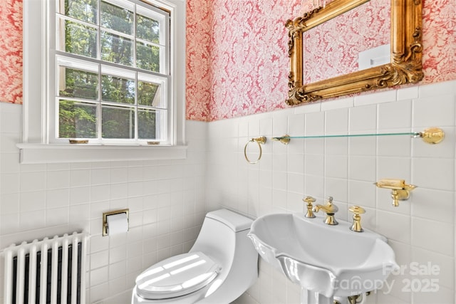 1233 General Hoke Dr, Lincolnton, NC 28092 - bathroom featuring radiator heating unit, toilet, a sink, tile walls, and wallpapered walls
