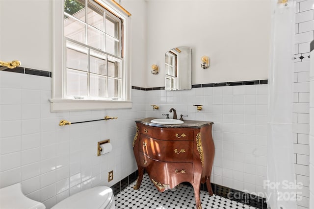 1233 General Hoke Dr, Lincolnton, NC 28092 - bathroom featuring toilet, tile walls, a wealth of natural light, and wainscoting