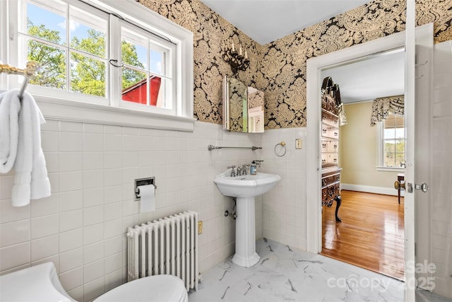 1233 General Hoke Dr, Lincolnton, NC 28092 - half bath featuring radiator heating unit, a sink, wainscoting, tile walls, and wallpapered walls