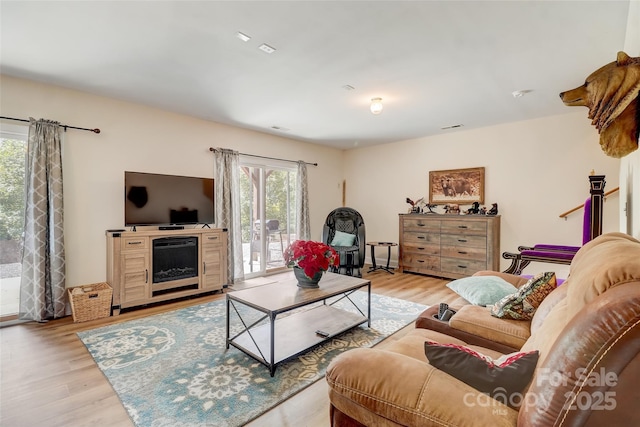 living room with visible vents and light wood-type flooring