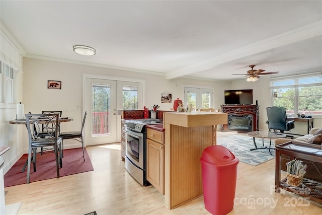 kitchen with french doors, plenty of natural light, electric range, and a glass covered fireplace