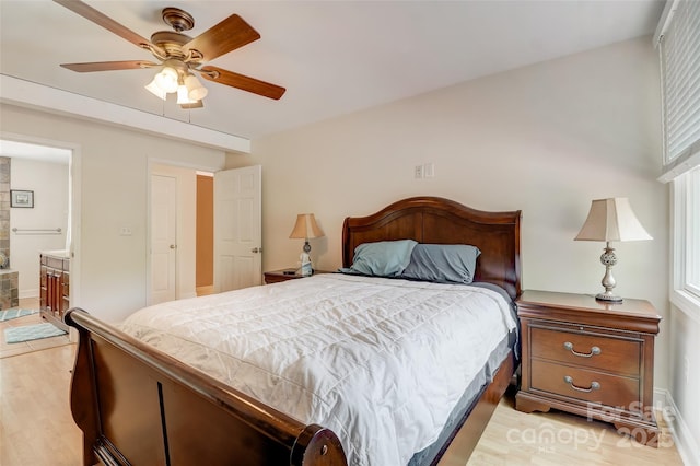 bedroom featuring light wood-style flooring, ceiling fan, ensuite bath, and baseboards
