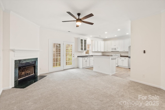unfurnished living room with crown molding, light colored carpet, ceiling fan, and recessed lighting
