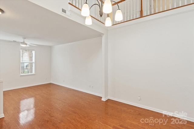 unfurnished room featuring visible vents, baseboards, a ceiling fan, and wood finished floors