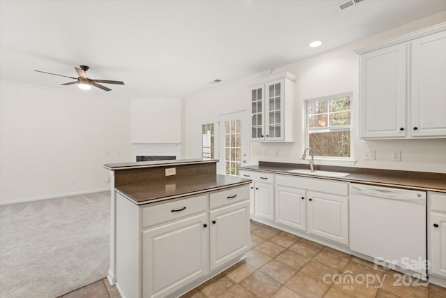 kitchen with a sink, ceiling fan, dark countertops, and dishwasher