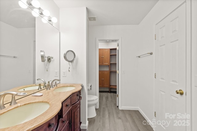 full bathroom with a sink, visible vents, and wood finished floors