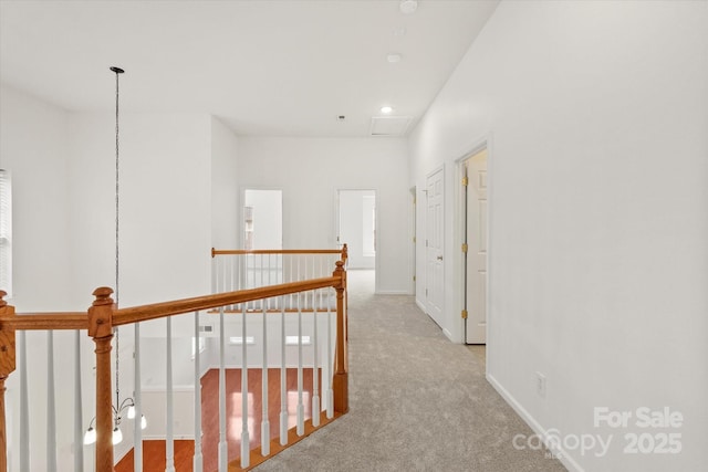 corridor with baseboards, an upstairs landing, and carpet floors