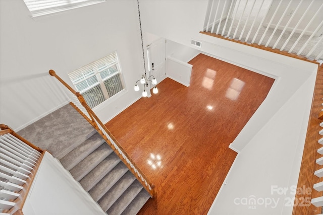 stairs with visible vents and a towering ceiling