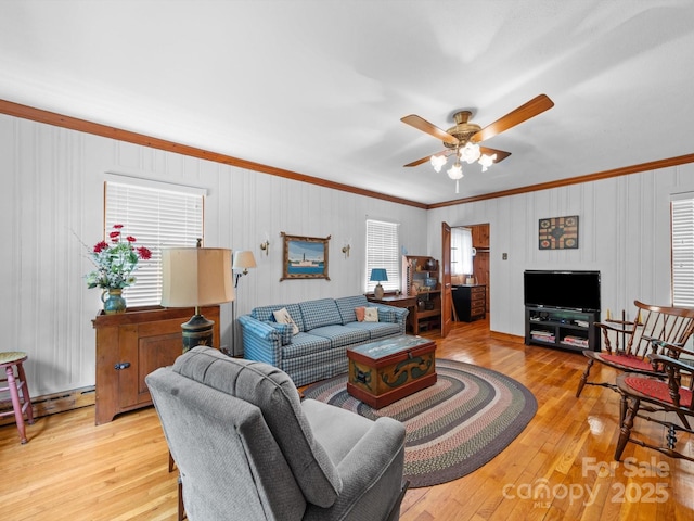 living room with crown molding, ceiling fan, and light wood finished floors