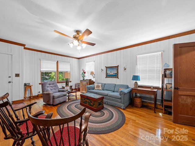 living room featuring a ceiling fan, light wood finished floors, and ornamental molding