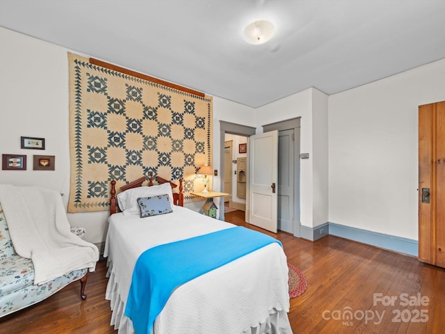 bedroom featuring baseboards and wood finished floors