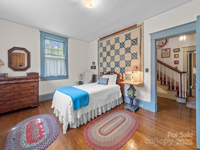 bedroom featuring baseboards and wood finished floors