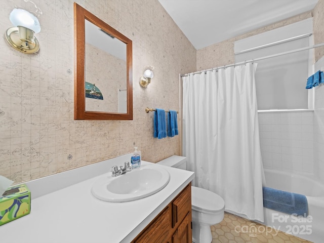 full bath featuring toilet, wallpapered walls, vanity, and shower / bath combo with shower curtain