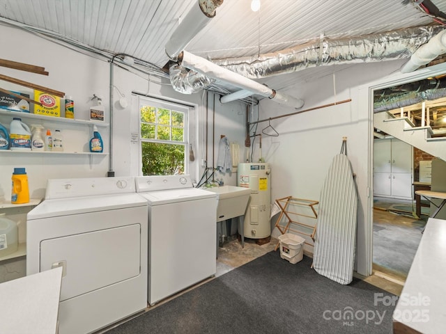 laundry area featuring water heater, independent washer and dryer, laundry area, and a sink