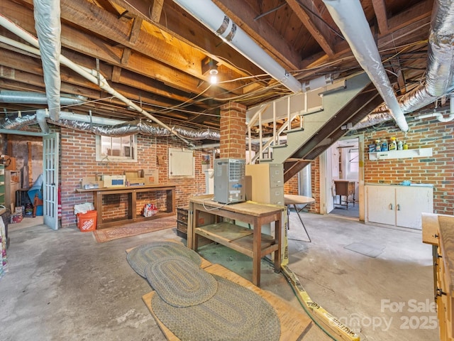 below grade area featuring stairway and brick wall