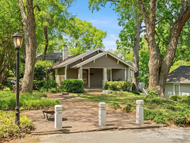 view of front of house featuring a porch and a chimney