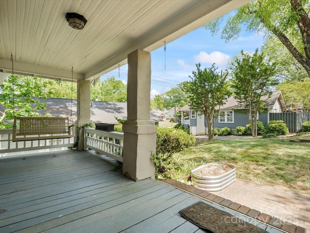 deck with a porch and a lawn