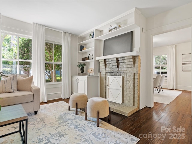 sitting room featuring baseboards, a fireplace, and dark wood-style flooring