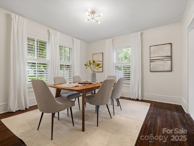 dining space featuring light wood-type flooring, baseboards, crown molding, and an inviting chandelier