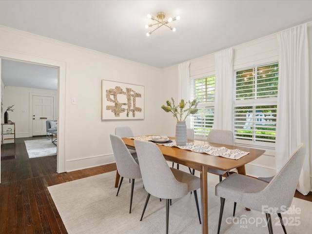 dining room featuring baseboards, ornamental molding, and dark wood finished floors