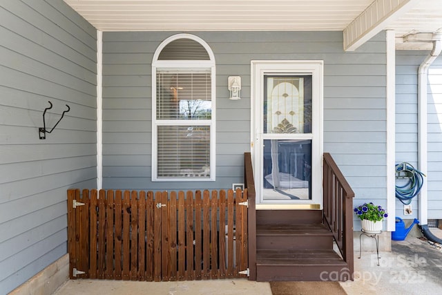 entrance to property featuring fence and a porch