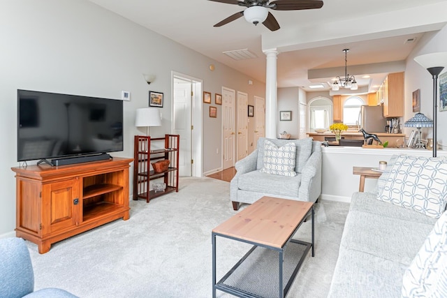 living area featuring ceiling fan, decorative columns, light carpet, and visible vents