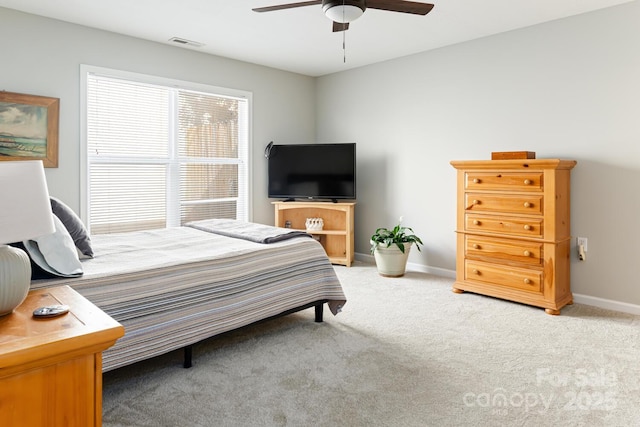 bedroom with light colored carpet, visible vents, ceiling fan, and baseboards