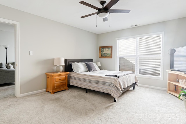 bedroom with visible vents, light carpet, and baseboards