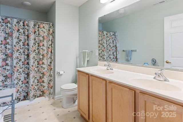bathroom with double vanity, visible vents, toilet, and a sink