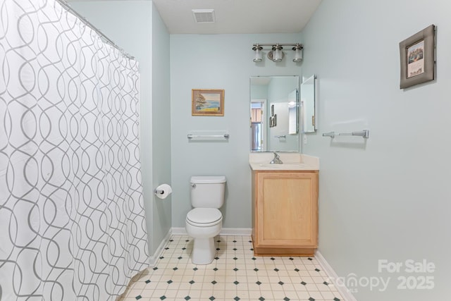 bathroom with tile patterned floors, toilet, vanity, baseboards, and visible vents