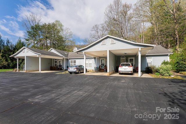 view of vehicle parking with driveway and an attached carport