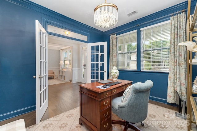 office space featuring french doors, a chandelier, a decorative wall, wood finished floors, and a wainscoted wall