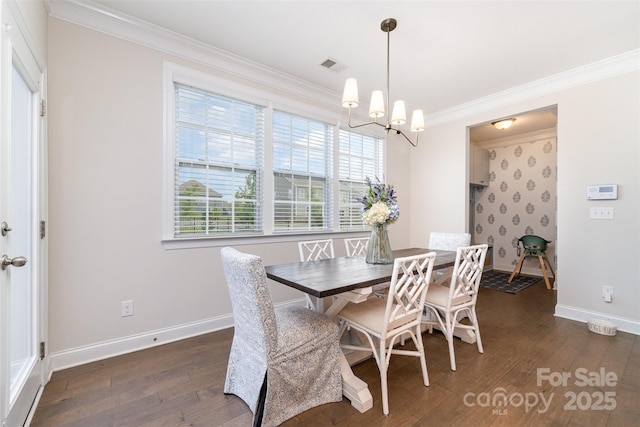 dining room with ornamental molding, a chandelier, dark wood-type flooring, and baseboards