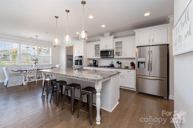 kitchen with stainless steel appliances, white cabinetry, a center island with sink, dark wood-type flooring, and recessed lighting