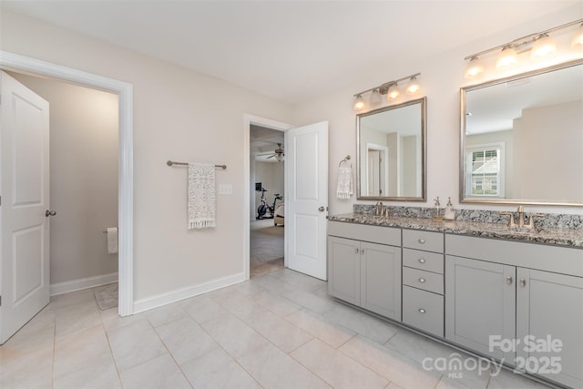 full bath featuring a ceiling fan, double vanity, tile patterned floors, and baseboards