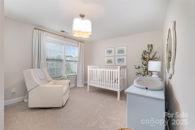 bedroom featuring a nursery area, carpet flooring, and baseboards